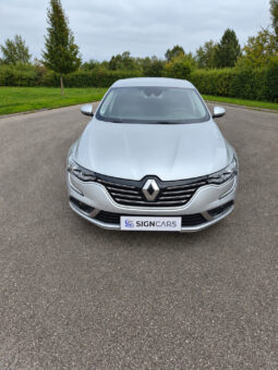 Renault Talisman devant une haie verdoyante