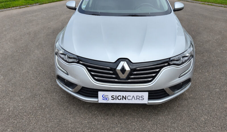 Renault Talisman devant une haie verdoyante